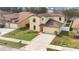 Two-story house with tan exterior and landscaping at 533 Woods Landing Dr, Minneola, FL 34715