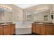 Bathroom with corner bathtub, double sinks, and wood cabinets at 533 Woods Landing Dr, Minneola, FL 34715