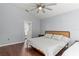 Bright bedroom with king-size bed, ensuite bathroom access, and hardwood floors at 562 Eagle Pointe S, Kissimmee, FL 34746