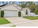 Tan house with white garage door and landscaping at 562 Eagle Pointe S, Kissimmee, FL 34746