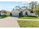 Tan house with white garage door, landscaping, and fence at 562 Eagle Pointe S, Kissimmee, FL 34746