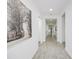 Bright and spacious hallway with tile floors and large wall art, leading to other rooms at 7901 Dausset St, Orlando, FL 32827