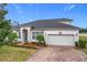 House exterior featuring a two-car garage and well-manicured landscaping at 9007 Eagle Cove Ct, Orlando, FL 32825