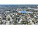 A serene neighborhood aerial view highlights a lakeside home with mature trees, and a nearby highway at 9511 Lake Douglas Pl, Orlando, FL 32817