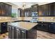 Kitchen features a large island with granite countertops and dark cabinets at 998 Nathan Ridge Rd, Clermont, FL 34715