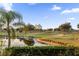 Landscaped backyard with palm trees, lake, and golf course views at 1400 Titian Ct, Reunion, FL 34747