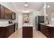 Modern kitchen featuring dark brown cabinets, quartz countertops, and stainless steel appliances at 149 Pine Rustle Ln, Auburndale, FL 33823