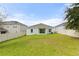 Spacious backyard with lush green grass enclosed by a white fence, offering plenty of room for outdoor activities at 1504 Finchburg St, Minneola, FL 34715