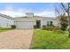 Charming single-story home with a well-manicured lawn and a brick driveway at 1504 Finchburg St, Minneola, FL 34715