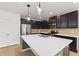 Island kitchen with stainless steel appliances, pendant lighting, white countertops and ample counter space at 1504 Finchburg St, Minneola, FL 34715