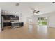 Open-concept living space with tile flooring, a modern kitchen, and sliding glass doors to the backyard at 1504 Finchburg St, Minneola, FL 34715