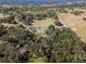 Aerial view of property showing home nestled amongst trees and pasture at 2850 Horton Rd, Kissimmee, FL 34744