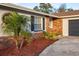 Brick ranch house with gray garage door and landscaping at 2855 Cady Way, Winter Park, FL 32792