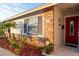 Brick ranch house with red front door and landscaped yard at 2855 Cady Way, Winter Park, FL 32792