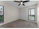 Bright bedroom featuring carpeted floors, a ceiling fan, and natural light from two windows at 2923 Marshfield Ct # Ge, Orlando, FL 32822