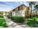 Side view of a tan condo building with manicured hedges and a walkway at 2923 Marshfield Ct # Ge, Orlando, FL 32822