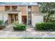 Tan two-story condo building with lush landscaping and a paved walkway at 2923 Marshfield Ct # Ge, Orlando, FL 32822