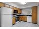 Bright kitchen with wooden cabinets, white appliances, black countertops, and tiled floor, ready for Gathering meals at 2923 Marshfield Ct # Ge, Orlando, FL 32822