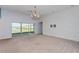 Spacious living room with carpeting, large windows, and a textured accent wall at 306 Quarry Rock Cir, Kissimmee, FL 34758