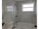 Clean bathroom with a bathtub, marble-tiled walls and a window at 32650 Azealia Pl, Tavares, FL 32778