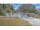 Newly renovated house with gray exterior, landscaping, and driveway at 32650 Azealia Pl, Tavares, FL 32778