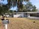 Gray house with carport, landscaping, and a spacious yard at 32650 Azealia Pl, Tavares, FL 32778