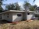 Gray house exterior with landscaping and a carport at 32650 Azealia Pl, Tavares, FL 32778