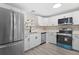 Modern kitchen featuring stainless steel appliances and white shaker cabinets at 32650 Azealia Pl, Tavares, FL 32778