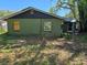 Back exterior of a home with overgrown landscaping and boarded up window, shows potential at 3421 Fudge Rd, Apopka, FL 32712