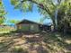 Back exterior of a home with overgrown landscaping and boarded up window, shows potential at 3421 Fudge Rd, Apopka, FL 32712