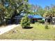 Inviting single-story home with a blue roof, complemented by a lush front lawn and mature trees, providing a serene setting at 3421 Fudge Rd, Apopka, FL 32712