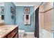 Bathroom with granite countertop, dark wood cabinets, and tub shower combo at 3799 S Atlantic Ave # 602, Daytona Beach, FL 32118
