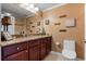Bathroom with granite countertop, dark wood cabinets, and toilet at 3799 S Atlantic Ave # 602, Daytona Beach, FL 32118