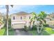 Two-story house with beige exterior and a three-car garage at 3915 Shoreview Dr, Kissimmee, FL 34744