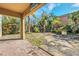 Spacious backyard with a stone patio, lush landscaping, and a grill at 3915 Shoreview Dr, Kissimmee, FL 34744