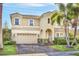 Two-story house with beige exterior and a three-car garage at 3915 Shoreview Dr, Kissimmee, FL 34744