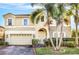 Two-story house with beige exterior and a three-car garage at 3915 Shoreview Dr, Kissimmee, FL 34744