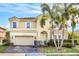 Two-story house with beige exterior, stone accents, and palm trees at 3915 Shoreview Dr, Kissimmee, FL 34744
