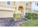 Front entrance with arched entryway, stone accents, and landscaping at 3915 Shoreview Dr, Kissimmee, FL 34744