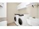 Bright laundry room with washer, dryer, cabinets, and a utility sink at 3915 Shoreview Dr, Kissimmee, FL 34744