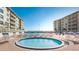 Community pool and spa with ample lounge chairs at 4153 S Atlantic Ave # 1020, New Smyrna Beach, FL 32169