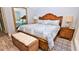 King-size bed, dresser and wicker bench in a light and airy bedroom at 4153 S Atlantic Ave # 1030, New Smyrna Beach, FL 32169
