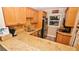 L-shaped kitchen with light wood cabinets, granite counters, and stainless steel appliances at 4153 S Atlantic Ave # 1030, New Smyrna Beach, FL 32169