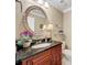 Elegant powder room with dark granite vanity, oval mirror, and decorative accents at 4208 Clubside Dr # 4208, Longwood, FL 32779