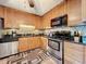 Renovated kitchen featuring stainless steel appliances and wood cabinetry, offering modern convenience at 4208 Clubside Dr # 4208, Longwood, FL 32779