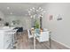 Modern dining area with glass table, white chairs, and a chandelier at 4386 Sw 169Th Lane Rd, Ocala, FL 34473