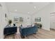 Open living area with teal sofas, wood-look floors, and a large TV at 4386 Sw 169Th Lane Rd, Ocala, FL 34473