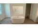 Bright bathroom featuring a standalone tub with modern fixtures and bright lighting at 5067 Northern Dove Ave, Mount Dora, FL 32757