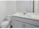 Clean half bathroom featuring a white vanity with a gray countertop and a toilet at 5067 Northern Dove Ave, Mount Dora, FL 32757
