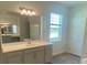 Bright bathroom featuring double sinks and a large mirror at 5067 Northern Dove Ave, Mount Dora, FL 32757